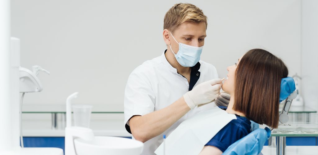 Zahnarzt kontrolliert den Zahn einer Frau zahn abgebrochen notdienst